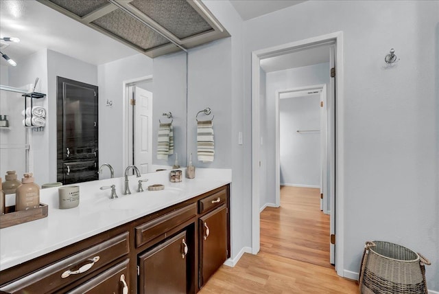 bathroom with baseboards, wood finished floors, and vanity