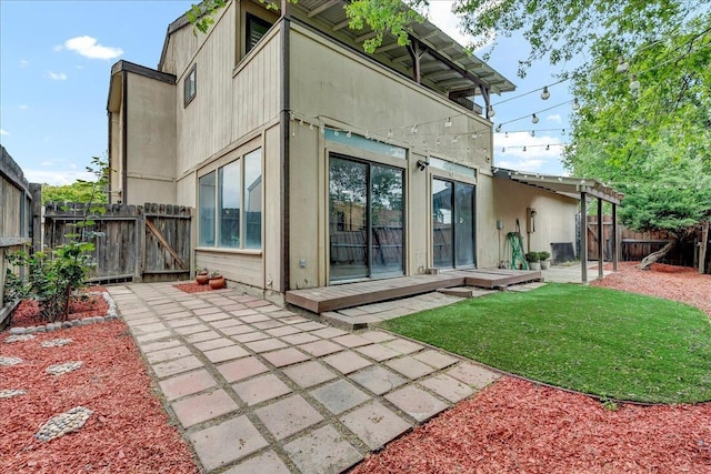 back of property featuring a gate, a patio area, a lawn, and a fenced backyard