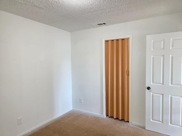 4571 N Kavanagh Ave, Fresno, CA 93705 - unfurnished bedroom with light colored carpet, a closet, a textured ceiling, and baseboards