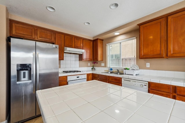 996 Papaya St, Madera, CA 93638 - kitchen with brown cabinets, recessed lighting, under cabinet range hood, white appliances, and decorative backsplash
