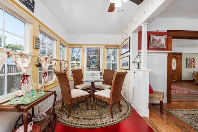 dining area featuring wood finished floors, ornamental molding, and a ceiling fan