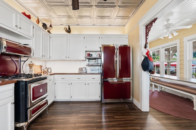 kitchen with white cabinetry, stainless steel range with gas cooktop, an ornate ceiling, ceiling fan, and freestanding refrigerator