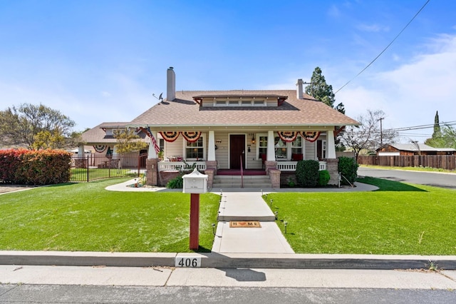 view of front of home with a front lawn, fence, a chimney, and a porch