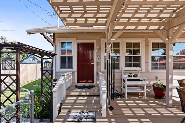 doorway to property featuring a pergola and fence