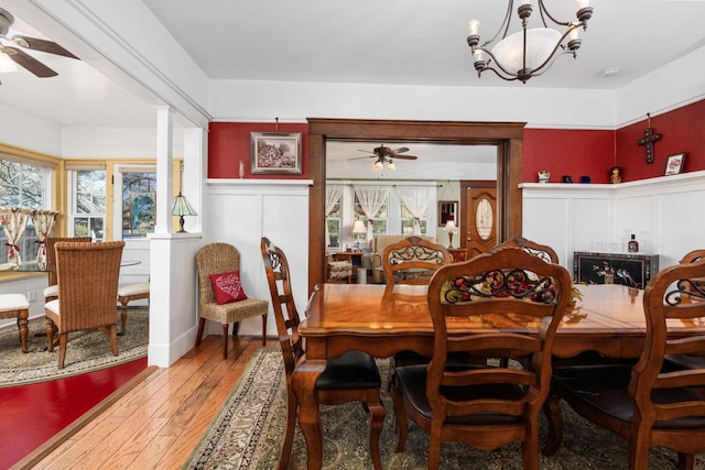 dining space featuring hardwood / wood-style floors, ceiling fan with notable chandelier, and plenty of natural light
