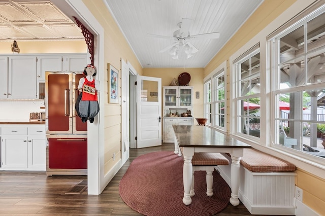 dining space with a ceiling fan and dark wood finished floors