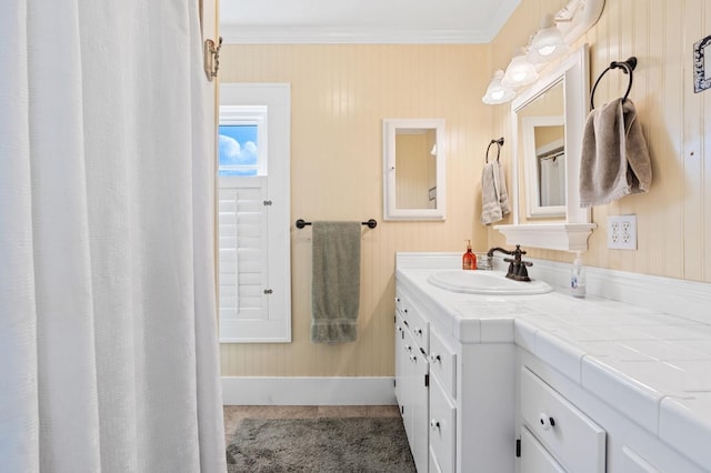 full bath with vanity, ornamental molding, and baseboards