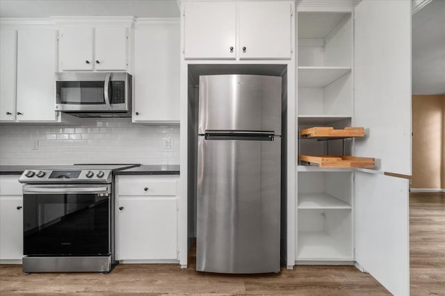 kitchen with white cabinetry, dark countertops, light wood-style flooring, and appliances with stainless steel finishes