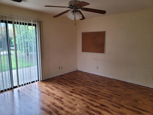 spare room with wood finished floors, baseboards, and ceiling fan