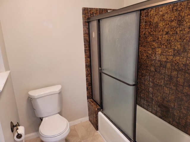 bathroom featuring shower / bath combination with glass door, tile patterned flooring, toilet, and baseboards