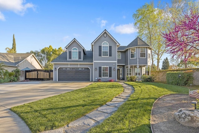 view of front of house featuring concrete driveway, roof with shingles, fence, a front lawn, and a garage