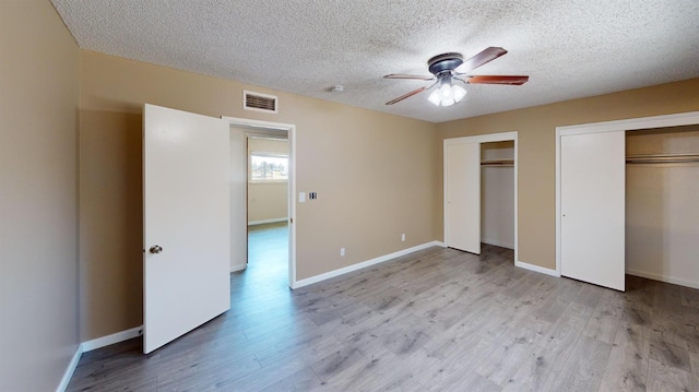 2299 N Garfield Ave, Fresno, CA 93723 - unfurnished bedroom featuring multiple closets, a textured ceiling, wood finished floors, and baseboards