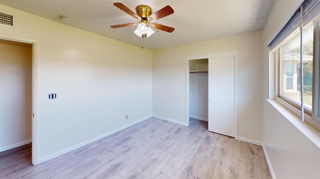 2299 N Garfield Ave, Fresno, CA 93723 - unfurnished bedroom featuring light wood-style flooring, baseboards, a closet, and a textured ceiling