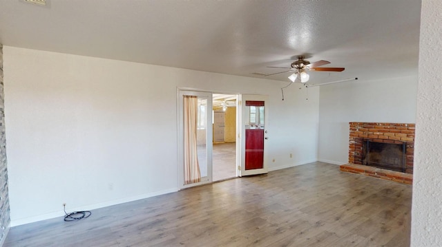 2299 N Garfield Ave, Fresno, CA 93723 - unfurnished living room featuring wood finished floors, a ceiling fan, a fireplace, and baseboards