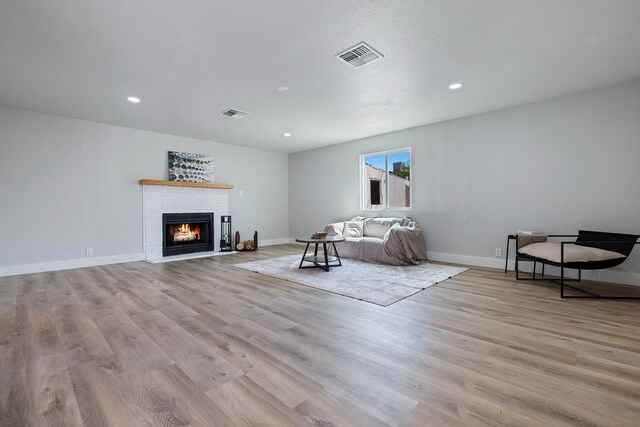 1633 W Saginaw Way, Fresno, CA 93705 - living area with wood finished floors, a brick fireplace, and recessed lighting