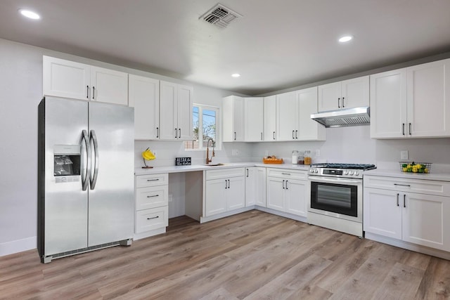 1633 W Saginaw Way, Fresno, CA 93705 - kitchen with stainless steel appliances, under cabinet range hood, light countertops, white cabinets, and recessed lighting