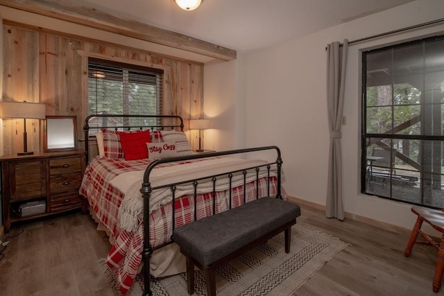 38660 Woodland Rd, Shaver Lake, CA 93664 - bedroom with multiple windows, wood finished floors, beamed ceiling, and baseboards