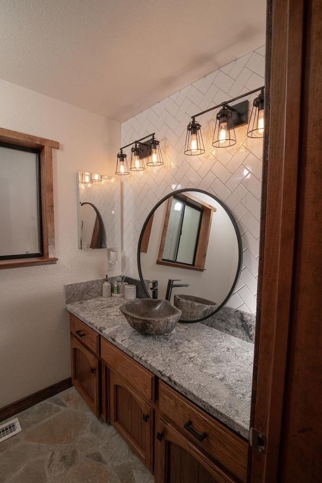 bathroom featuring vanity, baseboards, and visible vents