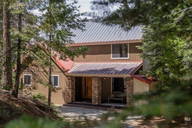 38660 Woodland Rd, Shaver Lake, CA 93664 - view of front of property with stone siding, a porch, and metal roof