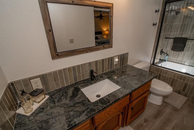 38660 Woodland Rd, Shaver Lake, CA 93664 - bathroom with toilet, tiled shower / bath, wood finished floors, vanity, and ceiling fan