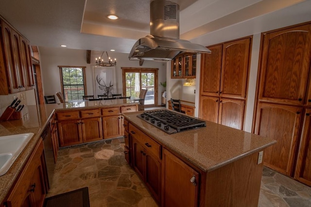 38660 Woodland Rd, Shaver Lake, CA 93664 - kitchen with gas cooktop, island exhaust hood, a chandelier, brown cabinetry, and a peninsula
