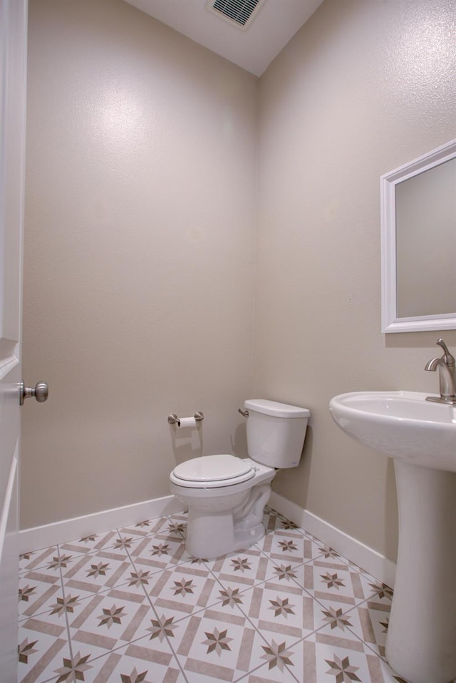 2791 E Tuolumne Rd, Turlock, CA 95382 - bathroom with toilet, baseboards, and tile patterned flooring