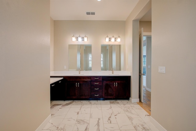 2791 E Tuolumne Rd, Turlock, CA 95382 - full bath with double vanity, marble look tile flooring, and baseboards
