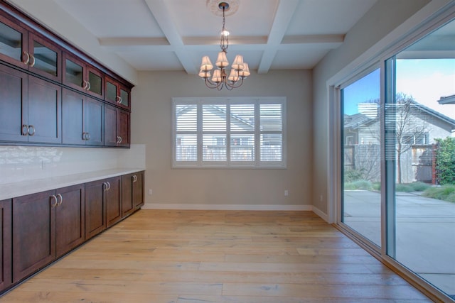 2791 E Tuolumne Rd, Turlock, CA 95382 - unfurnished dining area featuring a chandelier, coffered ceiling, beamed ceiling, light wood-style flooring, and baseboards