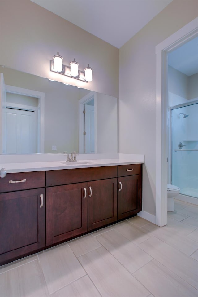 2791 E Tuolumne Rd, Turlock, CA 95382 - bathroom featuring a shower stall, vanity, toilet, baseboards, and tile patterned flooring