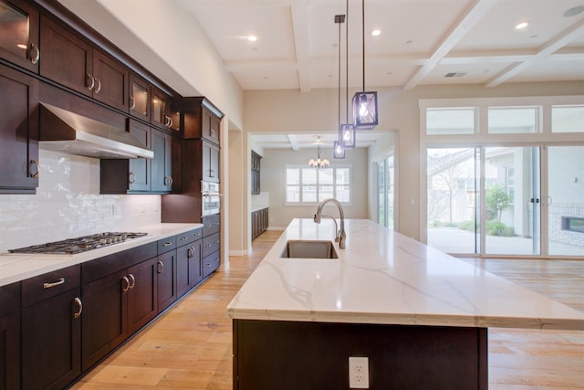 2791 E Tuolumne Rd, Turlock, CA 95382 - kitchen with a sink, stainless steel appliances, a center island with sink, light wood-type flooring, and backsplash