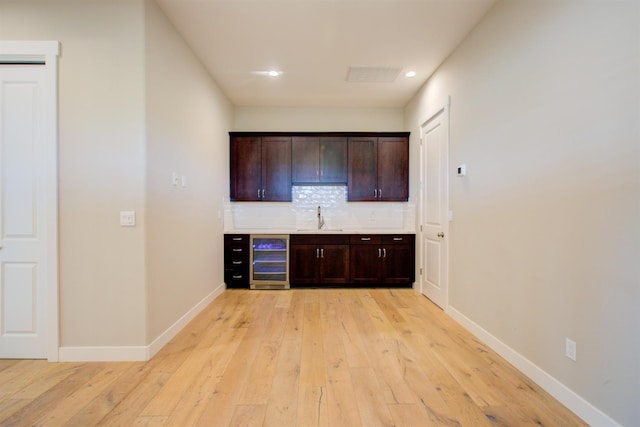 2791 E Tuolumne Rd, Turlock, CA 95382 - bar area featuring beverage cooler, light wood-style flooring, decorative backsplash, and recessed lighting