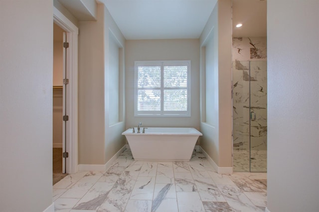 2791 E Tuolumne Rd, Turlock, CA 95382 - bathroom with a marble finish shower, a freestanding tub, marble look tile flooring, a walk in closet, and baseboards