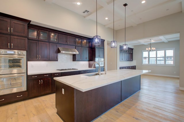 2791 E Tuolumne Rd, Turlock, CA 95382 - kitchen featuring stainless steel double oven, a sink, gas stovetop, coffered ceiling, and light wood-style flooring