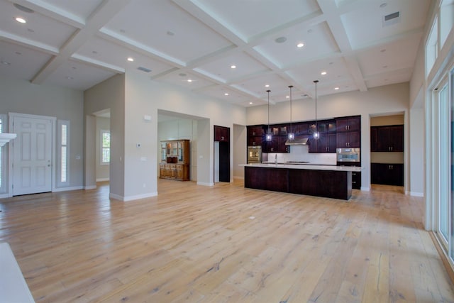 2791 E Tuolumne Rd, Turlock, CA 95382 - kitchen with stainless steel oven, open floor plan, coffered ceiling, a towering ceiling, and light wood-style flooring