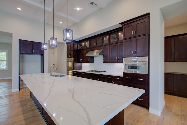 2791 E Tuolumne Rd, Turlock, CA 95382 - kitchen featuring a sink, gas cooktop, light wood-type flooring, wall chimney exhaust hood, and a spacious island