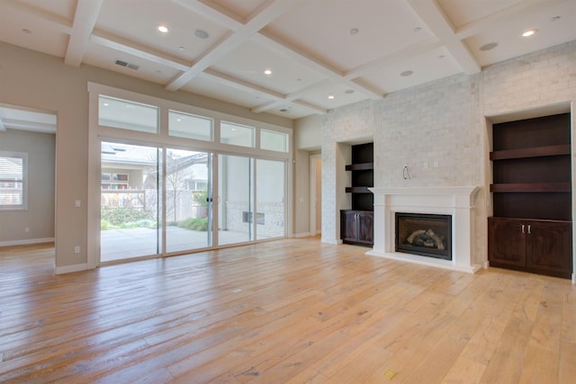 2791 E Tuolumne Rd, Turlock, CA 95382 - unfurnished living room featuring baseboards, light wood-style flooring, a fireplace with raised hearth, coffered ceiling, and beam ceiling