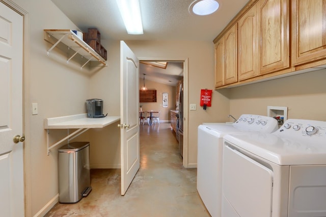 laundry area featuring baseboards, washer and dryer, cabinet space, and a textured ceiling