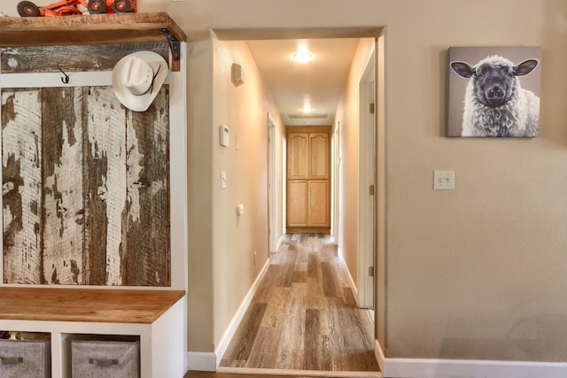 corridor featuring baseboards and wood finished floors