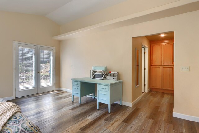 office featuring baseboards, lofted ceiling, light wood-style floors, and french doors