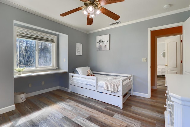 bedroom featuring baseboards, ornamental molding, and wood finished floors