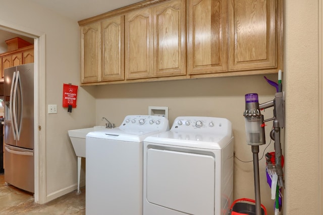 laundry area with cabinet space, washing machine and dryer, and baseboards