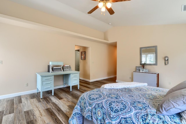 bedroom featuring baseboards, vaulted ceiling, visible vents, and wood finished floors