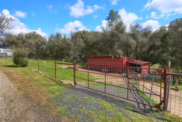view of yard featuring an exterior structure, an outdoor structure, and a rural view