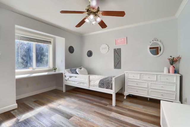bedroom featuring ornamental molding, baseboards, and wood finished floors