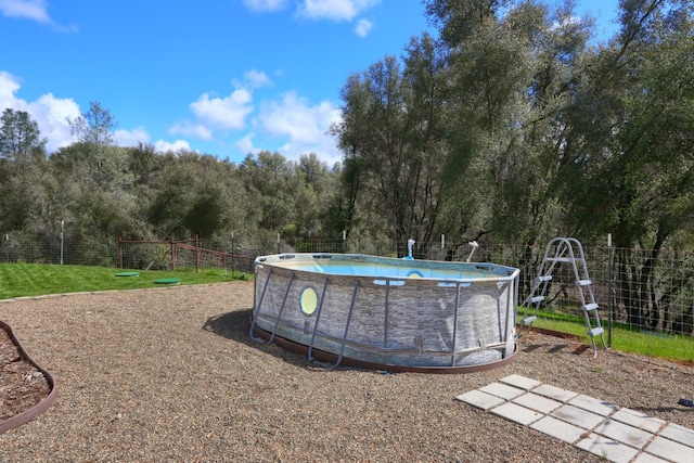view of yard featuring fence and an outdoor pool