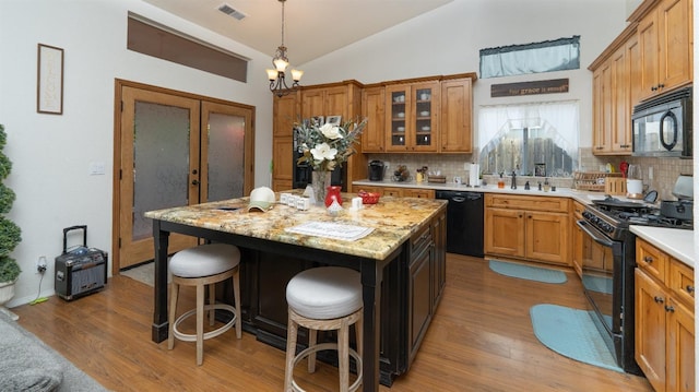 218 Casa Buena Ln, Coalinga, CA 93210 - kitchen featuring backsplash, vaulted ceiling, visible vents, and black appliances