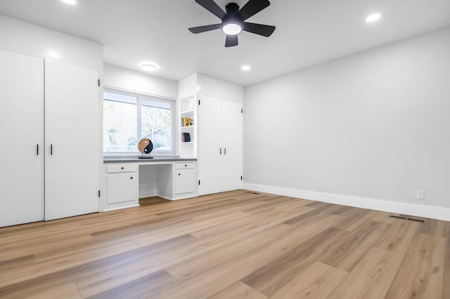 unfurnished bedroom featuring light wood-style floors, visible vents, recessed lighting, built in desk, and baseboards