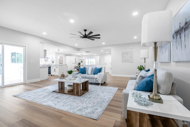 living area featuring recessed lighting, light wood finished floors, baseboards, and ceiling fan