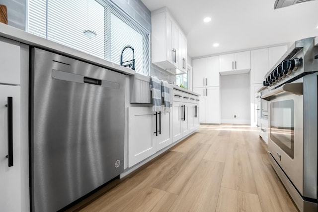 kitchen featuring light wood-type flooring, white cabinets, decorative backsplash, dishwasher, and wall oven