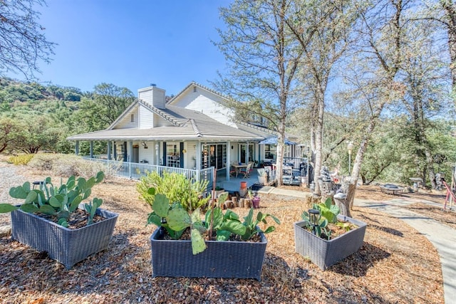 49521 Stillmeadow Dr, Oakhurst, CA 93644 - view of front of property with a patio area, a vegetable garden, and a chimney